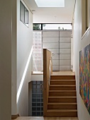Narrow stairwell with wooden stairs and entry area with front door
