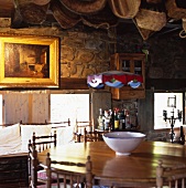 Round, wooden dining table and chairs with carved back rests in a Spanish kitchen in a country home