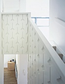 Treppenaufgang mit weißem geschnitzten Geländer und Blick in Schränkchen in Wohnraumecke