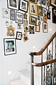 A traditional stairwell with a collection of photos in various frames