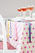 A table laid with a spotted tablecloth and decorative ribbons