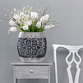White tulips in a vase on top of a small table