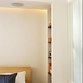 A built-in bookshelf in a corner of a bedroom