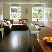 Küchenblock aus Nussholz mit Aufsatz aus Edelstahl vor gemütlicher Sofaecke am Fenster