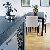 An esspresso machine on an island counter with a built-in wine rack