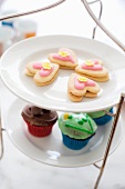Cake stand with heart-shaped biscuits and cupcakes