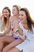 Three girls with watermelon on beach