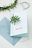 A menu card decorated with a sprig of rosemary
