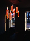 Light installation - orange glass balloons hanging from the ceiling in a darkened room