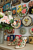 Wall decoration made of vintage tins and shoes with floral pattern