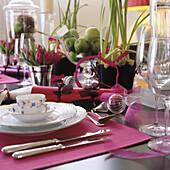 Festive table setting with tulips, green apples and pink placemats