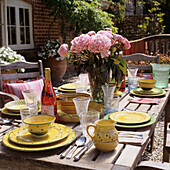 Laid garden table with bouquet of peonies