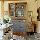 Display cabinet and console table with bouquet of flowers in rustic living room