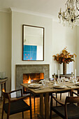 Dining room with fireplace, wooden chairs and chandelier