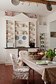 Cosy country kitchen with crockery on shelves and dotted tablecloth