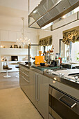 Modern kitchen with stainless steel appliances and dining area with chandelier