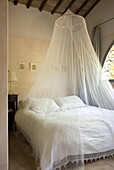 Bedroom with mosquito net and wooden beamed ceiling