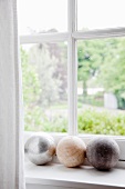 Decorative stone spheres on white windowsill