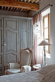 Vintage bedroom with wooden beamed ceiling and antique wardrobe