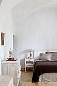 Schlafzimmer mit Gewölbedecke und weißer Vintage-Einrichtung