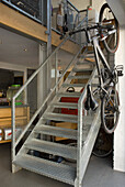Metalltreppe mit Geländer und daran aufgehängtem Fahrrad in einem Wohnraum
