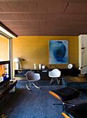 Retro-Wohnzimmer mit Designer-Stühlen und Wandkunst