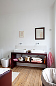 Minimalist bathroom with double washbasin and wooden floorboards