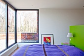 Bedroom with panoramic window and view onto sunny terrace