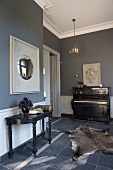 Taubenblau gestalteter Wohnraum in renoviertem Altbau mit antiken Möbeln und Tierfell auf dem Fliesenboden