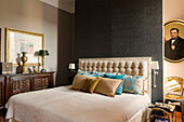 Bedroom with upholstered bed headboard and antique furniture