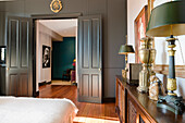 Bedroom with antique furniture and open double door to the living room