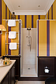 Small bathroom with yellow and purple striped walls and shower cubicle