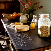 Breakfast table with muesli in a glass jar, bowl and jug