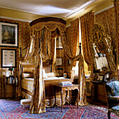 Bedroom with four-poster bed, patterns and oriental carpet