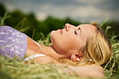 Blonde woman lies sleeping in hay