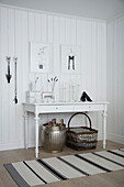 White console table with decorative elements in room with white paneled walls