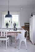 White dining room furnishings with rustic wooden table and various chairs