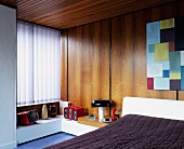 Wood-panelled, fifties-style bedroom with vertical blinds at window