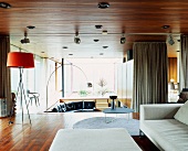 Spacious open-plan living space with light sofa and various Bauhaus-period standard lamps