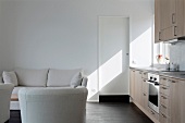 Light, upholstered furniture in open-plan kitchen