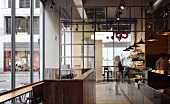 Industrial style in London coffee bar with glass wall and lighting concept using pendant lights and ceiling spots