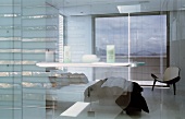 Blick vom Bad mit Glaswänden auf Schlafbereich mit Bett & Balkon