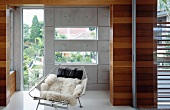 Seating area in small porch with wood panelling & concrete walls