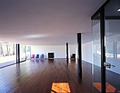 Offener leerer Wohnraum mit ausgestellten farbigen Sesseln