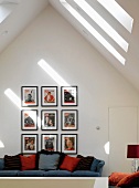 Bildersammlung über Sofa mit Kissen im Dachgeschoss mit Fenstern
