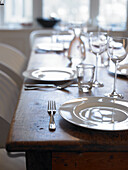 Set table with white crockery and glasses