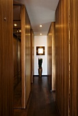 Wooden installations in narrow corridor with potted plant at far end