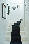 Schwarz-weiße Treppe mit Bilderrahmen an der Wand