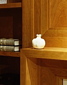 Vase on shelf in front of wood-panelled wall