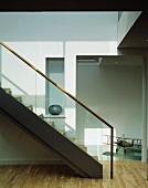 Contemporary staircase in bright stairwell with ceiling-height doorway to corridor
